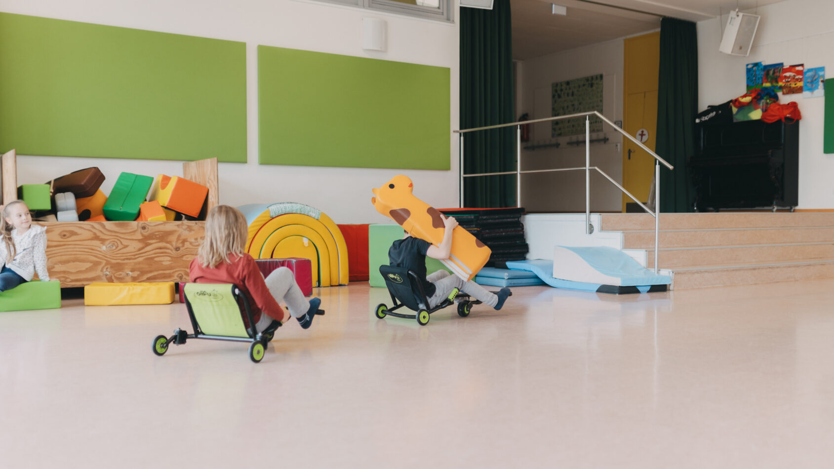 Zwei Kinder fahren mit Tretautos
