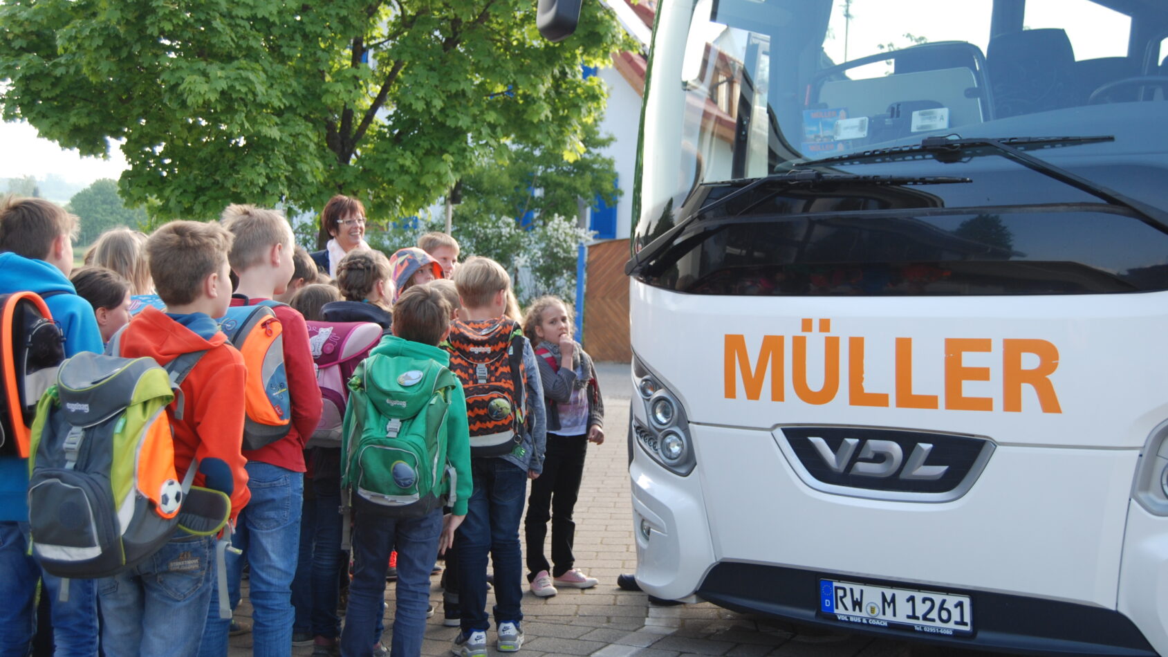 Kinder stellen sich vor dem Bus auf