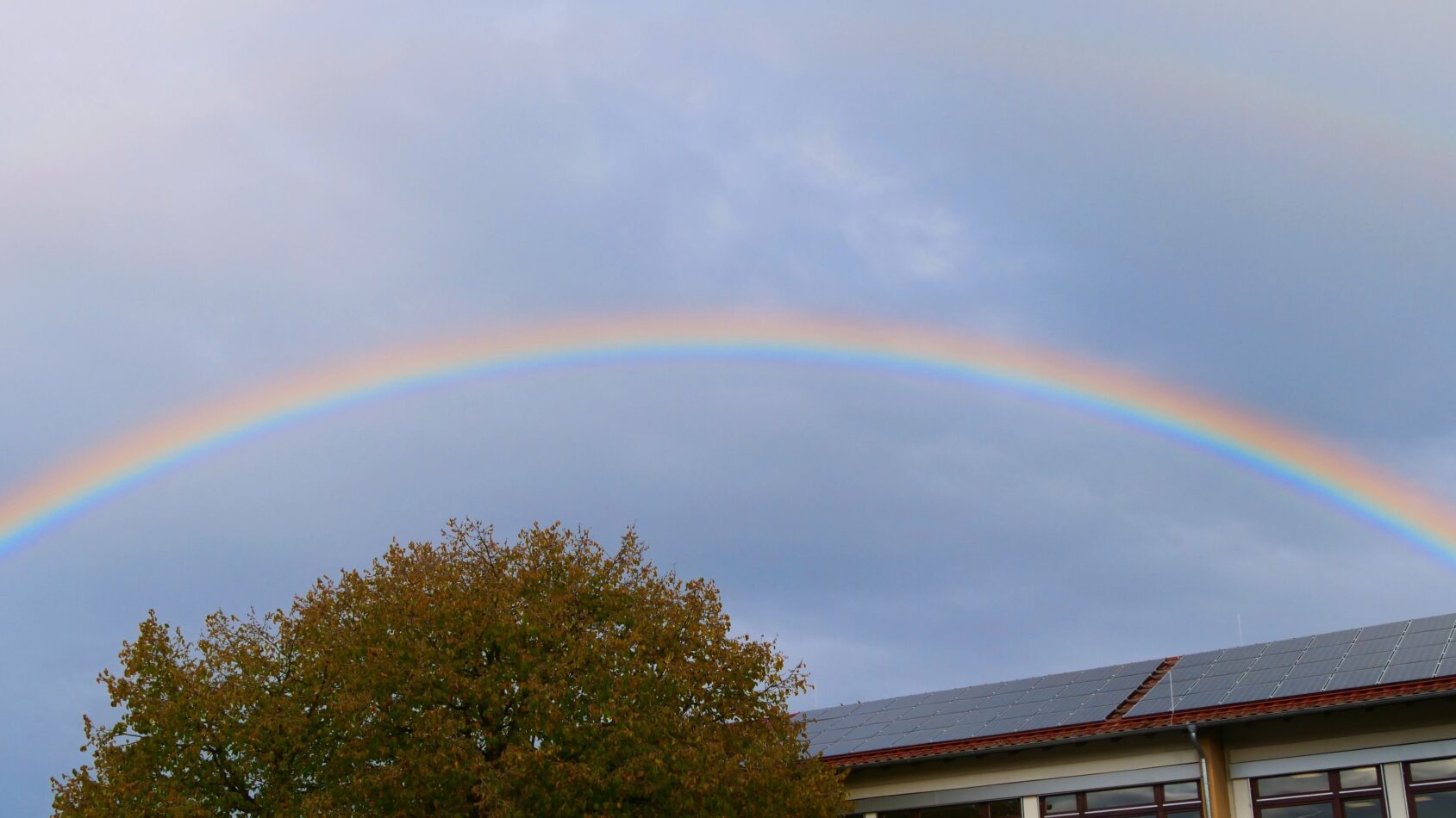 Regenbogen über dem Schulgebäude