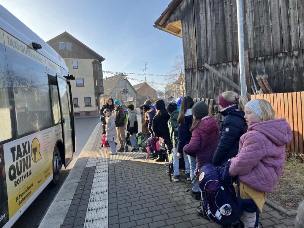Kinder stellen sich an Busbahnhof auf